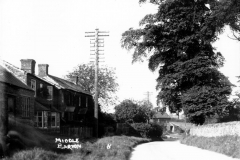 1920s From Enstone Road, looking east to the crossroads. On the south side, the wall and trees have now gone.