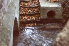 Bridge at the junction of Kiddington Road and South Street. Steps to a 'keaching stone' where people used to fetch water from the brook.