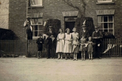 1935 George V Silver Jubilee - Putting up decorations in North Street. Mr. Walter Hazell on the ladder, Victor Hazell (boy). Bill Irons, Florence Hazell, Ethel Jarvis, Rose West, Tom Hazell, Sid Cox (?). Three girls - l to r Diana Jarvis, Violet Hazell, Barbara Jarvis.