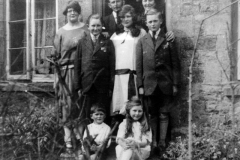 Stewart family l -> r in doorway: Solomon and Eliza Stewart; middle row: Edie, Sid, Doll and Bob; front row: William, Muriel.