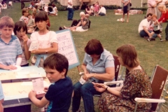 c. 1980 Middle Barton School Fete. Jamie Edbury, Tanya Southam, Tamsin Blencoe, Luke Morgan. Unknown. Teacher sitting on right is Mary Barker.  (School 2)
