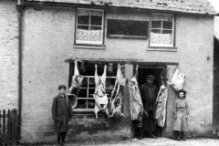 c. 1903 Thomas Grace Barrett in the butcher's shop doorway.