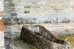 By Church porch. Mediaeval tapered coffin, believed to have come from Eynsham Abbey, which served for some years as a water trough at Whistlow Farm.