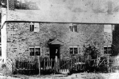 One of the cottages in the fields. Emma Luing in the doorway - demolished in 1933. The stones were carted by Charles Boffin to his yard in Worton Road (see Newman ledger) and many stones, thought to be old, were re-used.