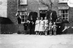 1935 George V Silver Jubilee - Putting up decorations in North Street. Mr. Walter Hazell (Cogger) on the ladder, Victor Hazell (boy). Bill Irons, Florence Hazell, Ethel Jarvis, Rose West, Tom Hazell, Sid Cox. Three girls - l to r Diana Jarvis, Violet Hazell, Barbara Jarvis.